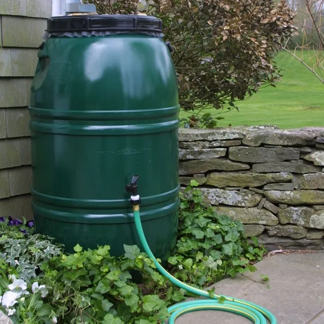 a rain barrel with a garden hose connected